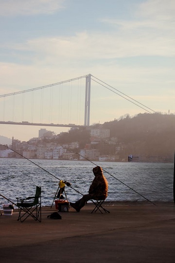 Üsküdar sahilinde sabah saatlerinde olta ile balık tutan amatör balıkçı
