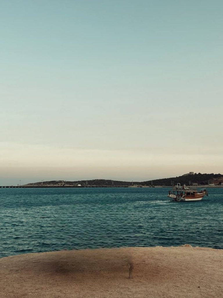 Taşucu kıyısında balık tutan balıkçı ve liman çevresinin doğal manzarası